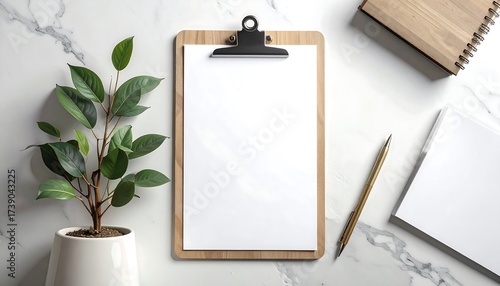 Elegant workplace setup featuring a clipboard, plant, and office supplies on marble