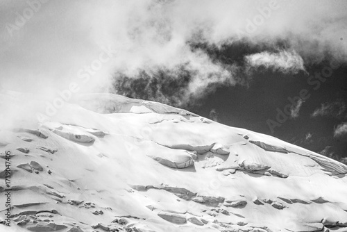 A close-up of a mountain peak in bad weather, leading to the death of climbers in windy weather, snow-capped peaks in the clouds