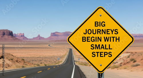 Yellow road sign with inspirational quote big journeys begin with small steps in desert landscape