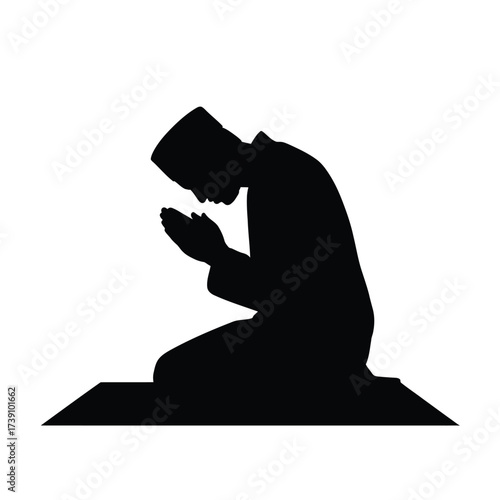 Black silhouette of a man praying on a mat kneeling