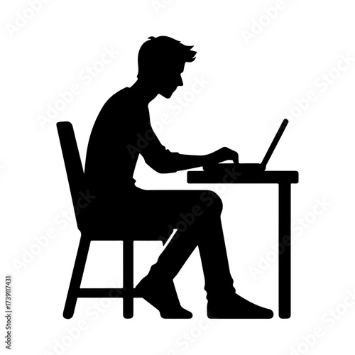 Silhouette of a man working on a laptop at a desk