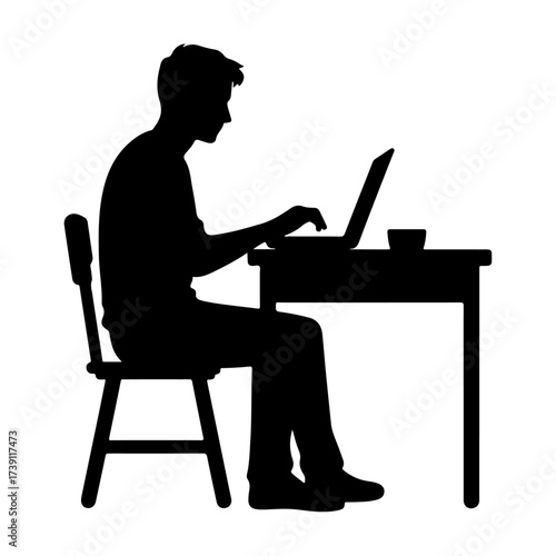 Silhouette of a man working on a laptop at a desk