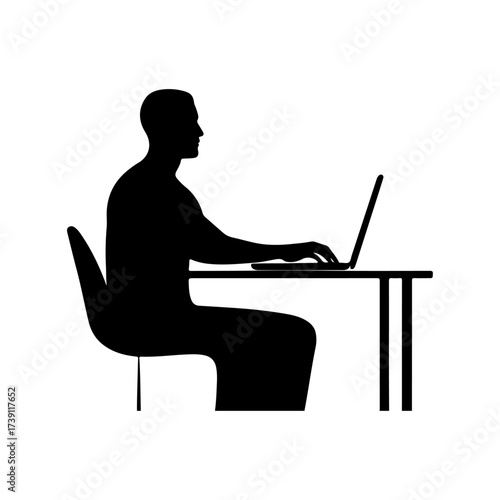 Silhouette of a man working on a laptop at a desk