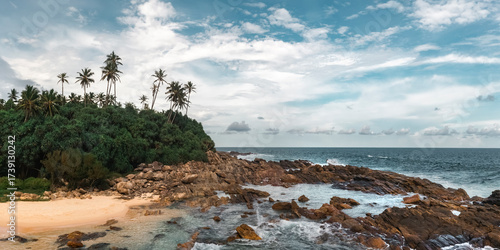 Fotografía Tropical Rocky Beach With Palm Trees And Ocean Waves Under Blue Sky