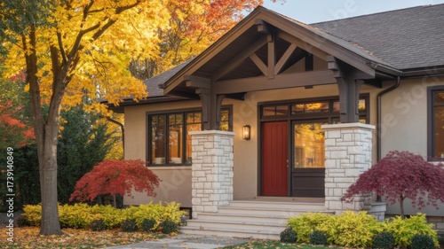 Beautiful craftsman style home exterior in autumn with colorful foliage and a red front door creating a warm and inviting curb appeal for the season
