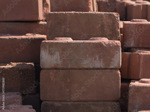 Old red bricks piled up on an outdoor lawn