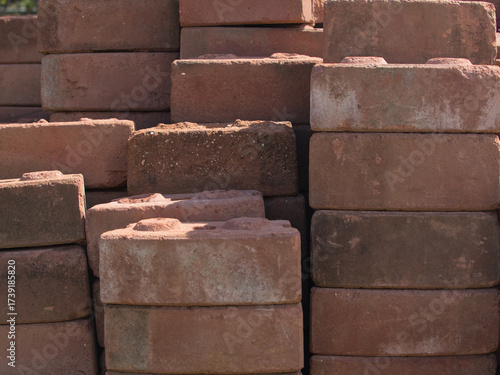 Old red bricks piled up on an outdoor lawn