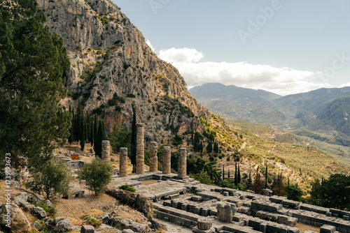 Ancient stone columns of the Temple of Apollo in Delphi with mountain landscape in the background, Greece