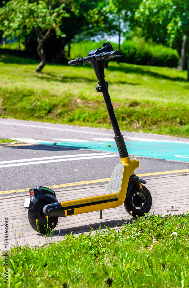 Fototapeta premium Yellow electric scooter are parked on a city Park 