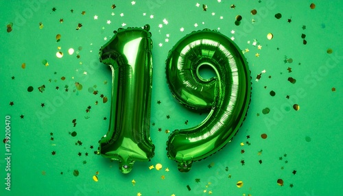 Green balloon number 19 with confetti on solid colored background. Photo for anniversary or birthday party