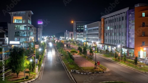 Modern cityscape at night illuminated buildings and empty road