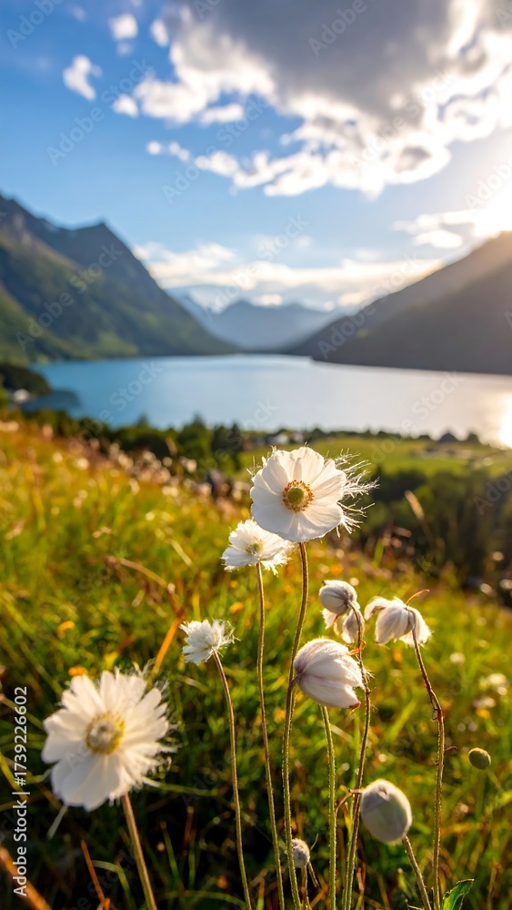 Fototapeta premium Scenic view of a lake nestled between mountains, wildflowers in the foreground