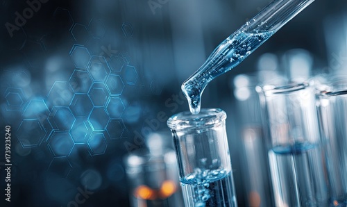 Close-up view of a pipette dispensing blue liquid into a test tube, with a hexagonal design