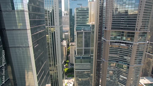 Aerial View of Urban Skyline: Tall Glass Buildings and Cityscape with Green Spaces Between Modern Skyscrapers in a Bustling Metropolis