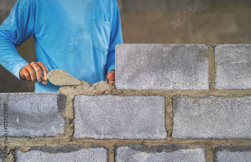  man is laying bricks on  wall