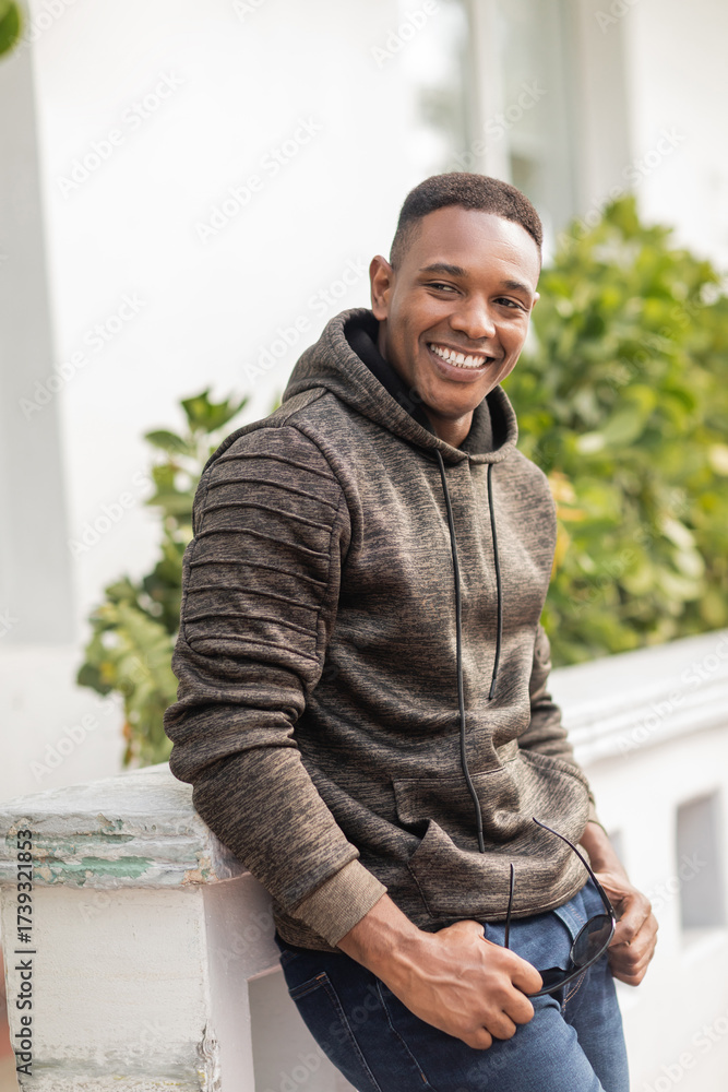 Fototapeta premium Handsome man in a hoodie enjoying autumn in sunny Miami