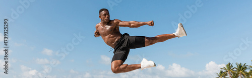 Muscular man performing an impressive kick during a workout session in Miami