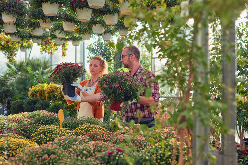 Wallpaper Mural Man and woman working in a flower nursery greenhouse, taking care of plants and preparing it for selling. Torontodigital.ca