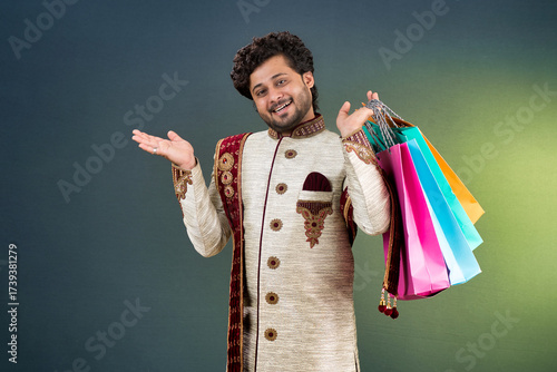 Indian traditional Young handsome man holding and posing with shopping bags