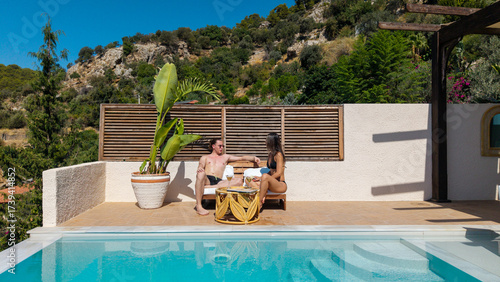 фотографія Idyllic Oasis: A couple enjoys a serene moment by the pool, soaking up the tranquil atmosphere