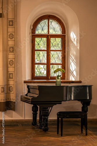 Grand piano under arched window with traditional decor