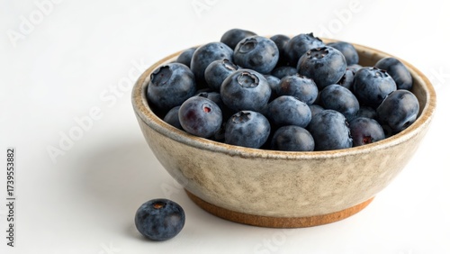 Fresh blueberries in a rustic bowl on a white background