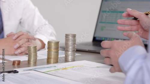 Financial advisor exchange meeting with investment coins and business charts for wealth management consultation