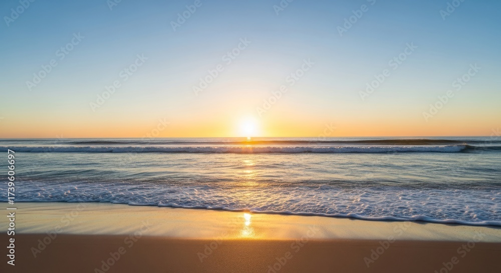 Obraz premium Golden sunrise over ocean waves meeting the sandy beach; serene, peaceful view