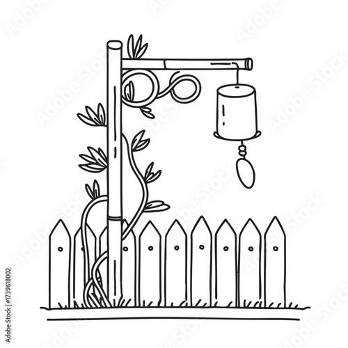 A wind chime beside a bamboo fence with vines creeping along