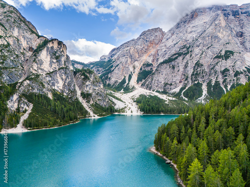 Lago di Braies or Lake Braies crystal blue lake with wooden rowing boats in Italian Dolomites. Mountain forest lake in Italian apls Dolomites South Tyrol. Mountain summit ridge. Glacier lake. 