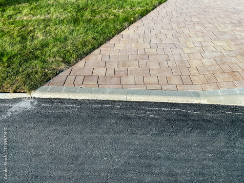 Fotografie An elegantly designed paver driveway completed with freshly laid asphalt and ado