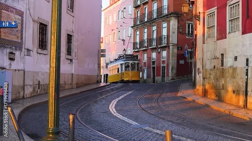 A classic fampus  yellow tram passes by vibrant red historic buildings in Lisbon  early sunrise morning