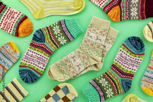 Colorful socks on a green background. Sock-shaped clothing for the cold season.