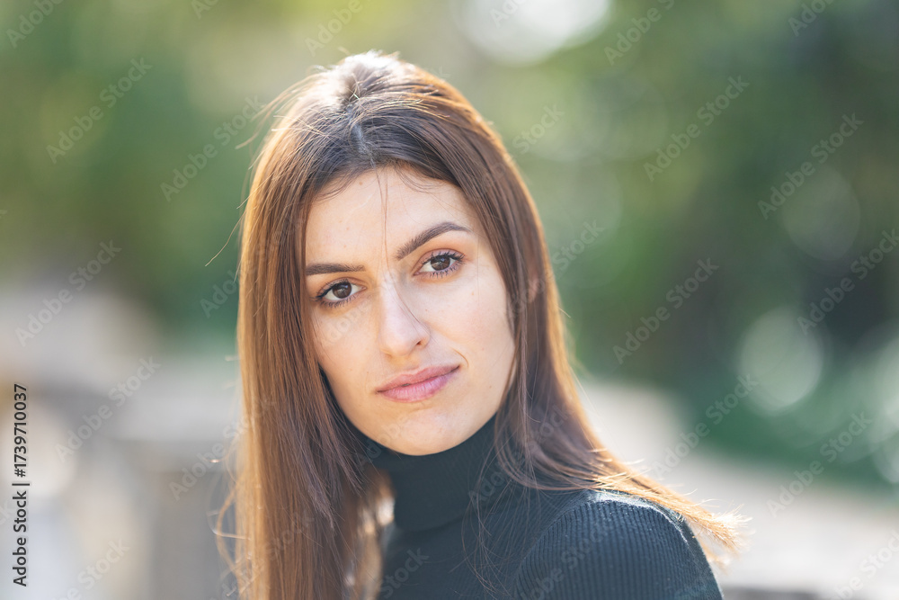 Naklejka premium Young woman confidently looking at camera in park