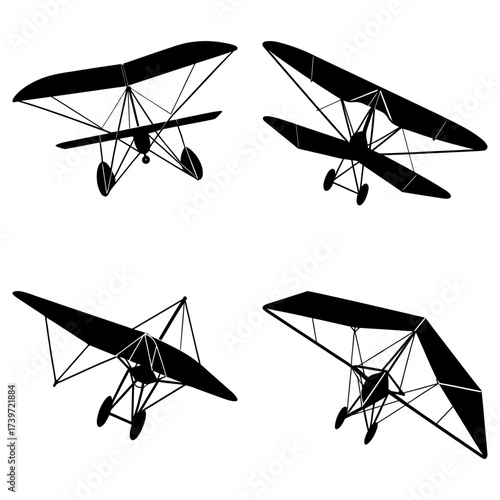 Four hang gliders in different orientations displayed as black silhouettes against a white background plane