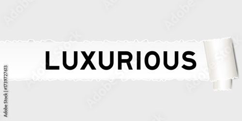 Ripped gray paper background that have word luxurious under torn part