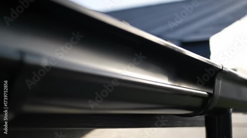 Modern House Gutter System Close Up - Close-up view of a sleek, black gutter system on a modern house, showcasing its clean lines and efficient design.