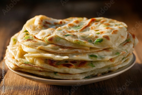 Chinese scallion pancakes stacked neatly, rustic wooden table