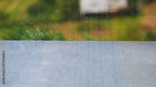 Raindrops fall on a windowsill during a rain. Raindrops on glass. Slow motion.