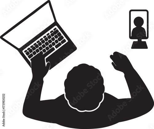 Silhouette of a person looking up at a laptop screen while holding a smartphone with a video call participant visible