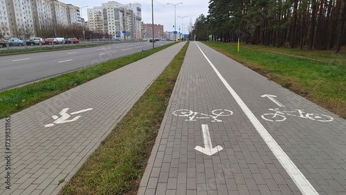 Εκτύπωση καμβά There is a tiled sidewalk and a designated bike path between the roadway and the park