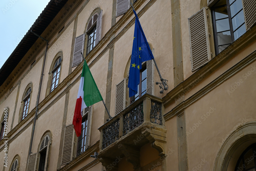 Fototapeta premium Drapeau Italien et drapeau de l'Union Européenne sur la façade d'un immeube de Sienne