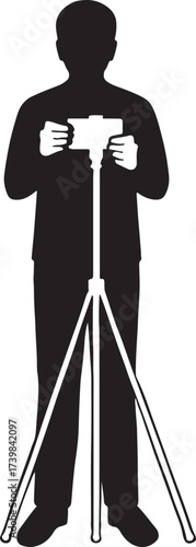 Silhouette of a person holding a camera mounted on a tripod capturing a moment or taking a photograph