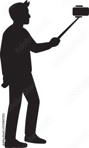 Silhouette of a person holding a selfie stick with a camera or phone attached capturing a self portrait