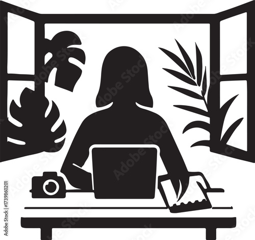 Silhouette of a woman working on a laptop at a desk with a camera and tablet surrounded by plants and a window view
