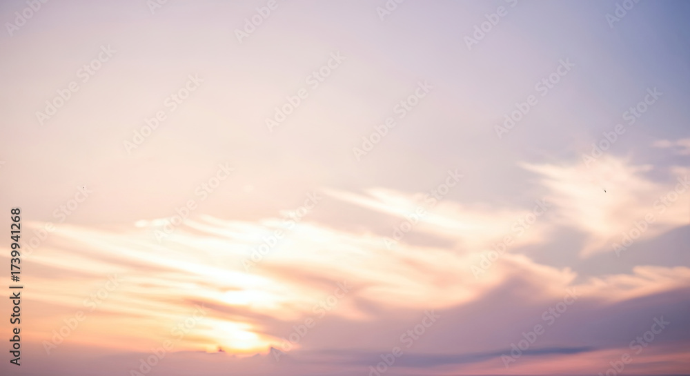 Fototapeta premium A serene sunset sky with soft, pastel hues and wispy clouds.