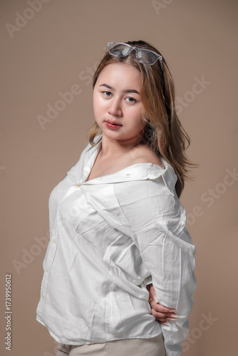 Asian woman wearing a white shirt with casual pose, natural makeup, and confident expression, representing modern lifestyle and professional concept.