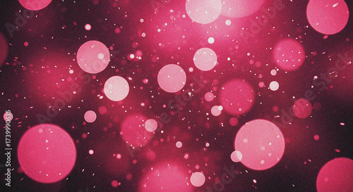 Abstract pink and red bokeh lights with glittering sparkles on a dark background