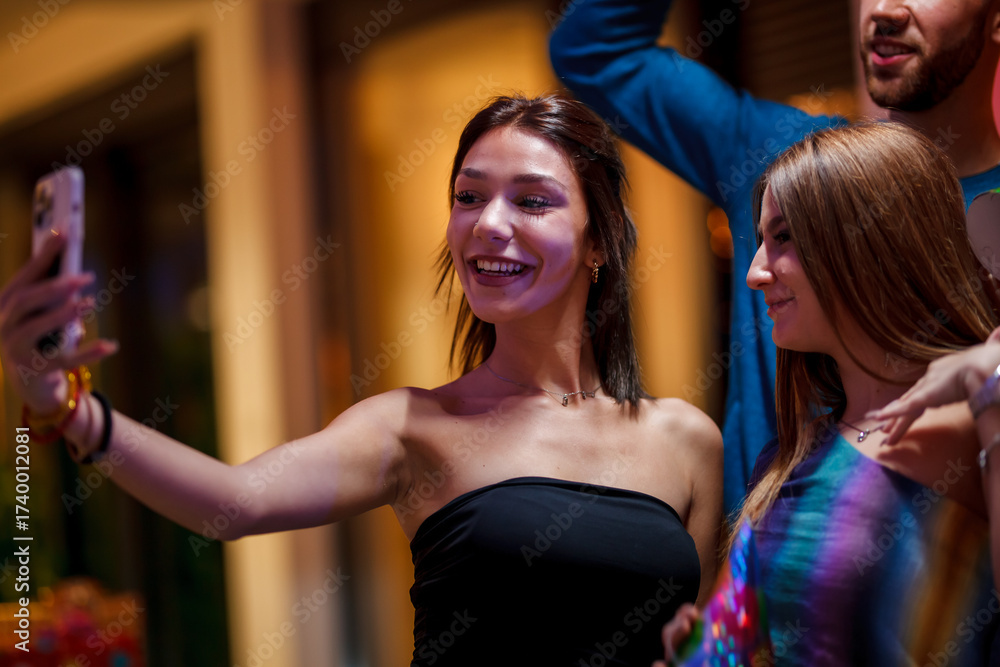 Fototapeta premium Group of smiling friends taking a selfie during social event