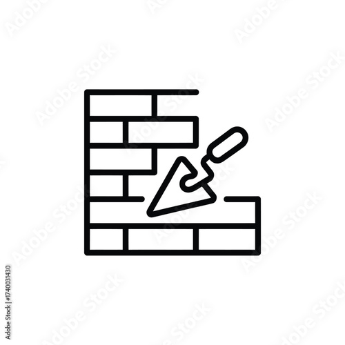Bricklaying trowel working on a new brick wall construction